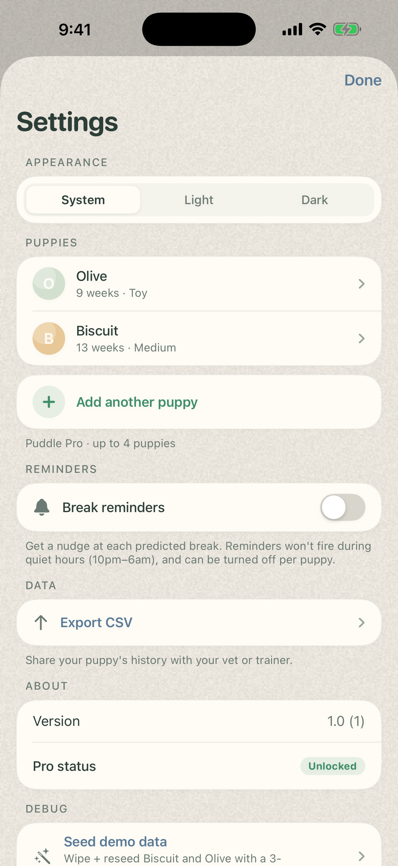 Puddle Settings showing appearance picker, two puppies in the list with their photos, Add another puppy in green, Break reminders, Export CSV, and the Pro Unlocked badge